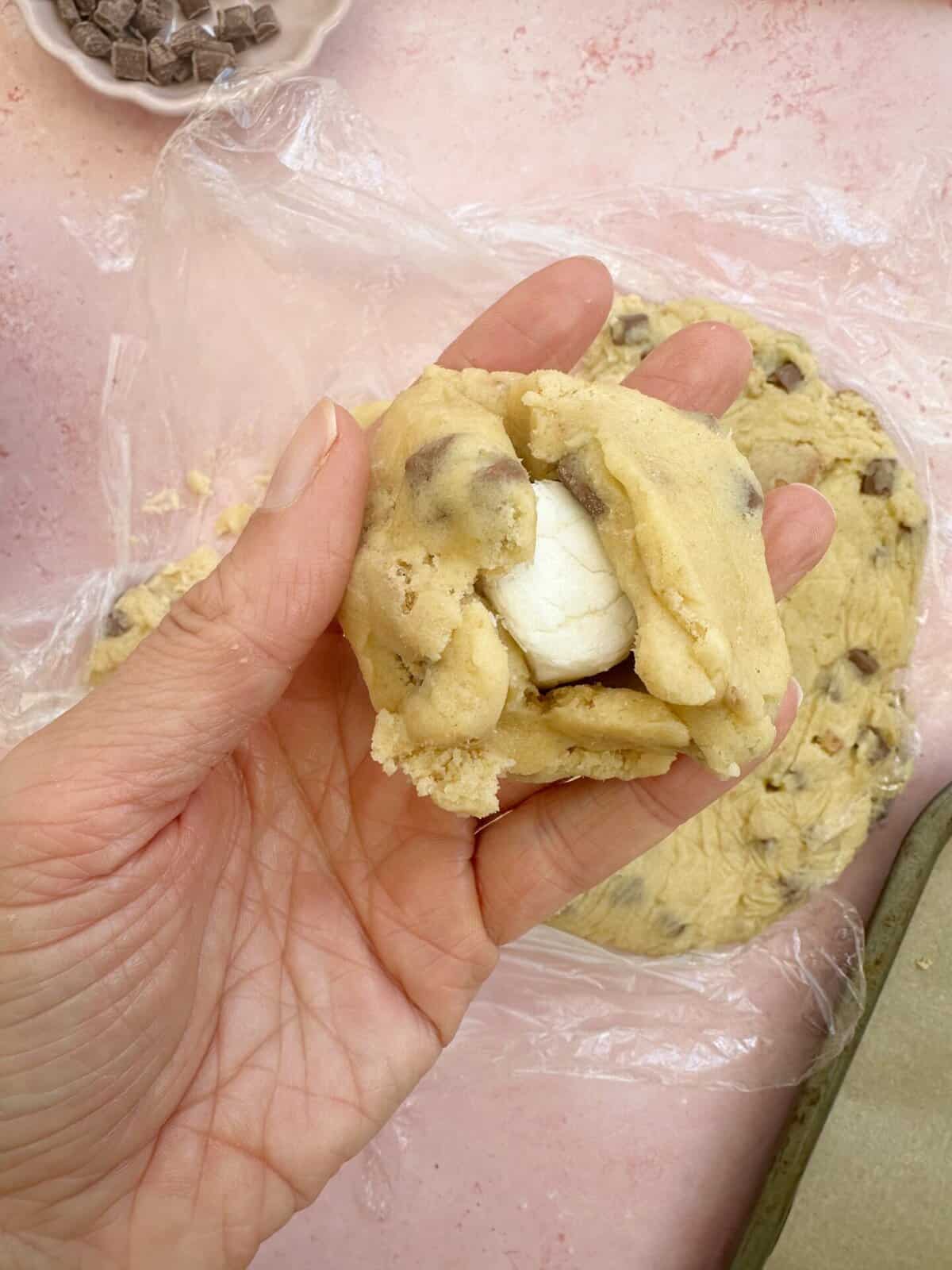 Shape the cookie dough around the marshmallow until it is sealed.