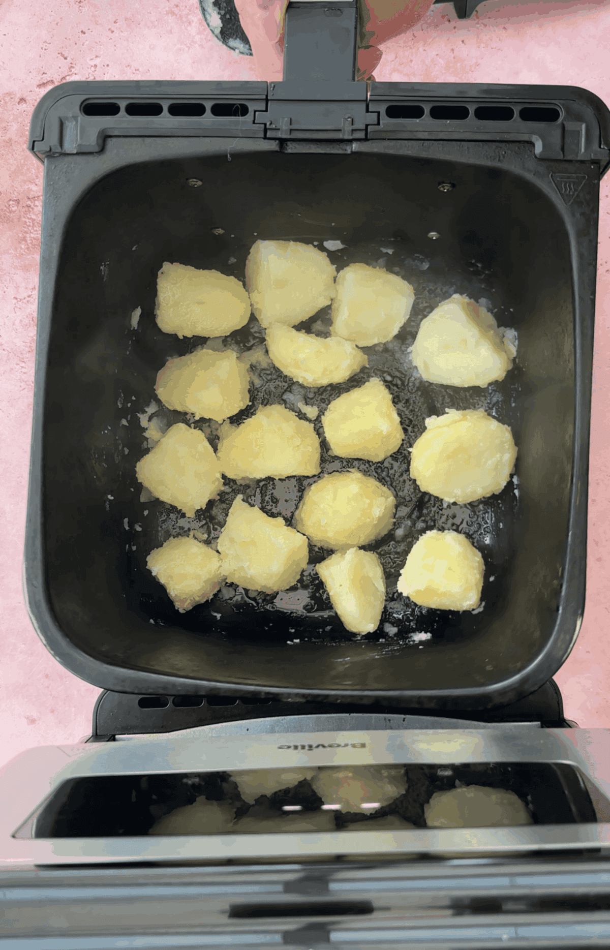 Add the potatoes to the air fryer basket in an even layer and toss in oil and salt.