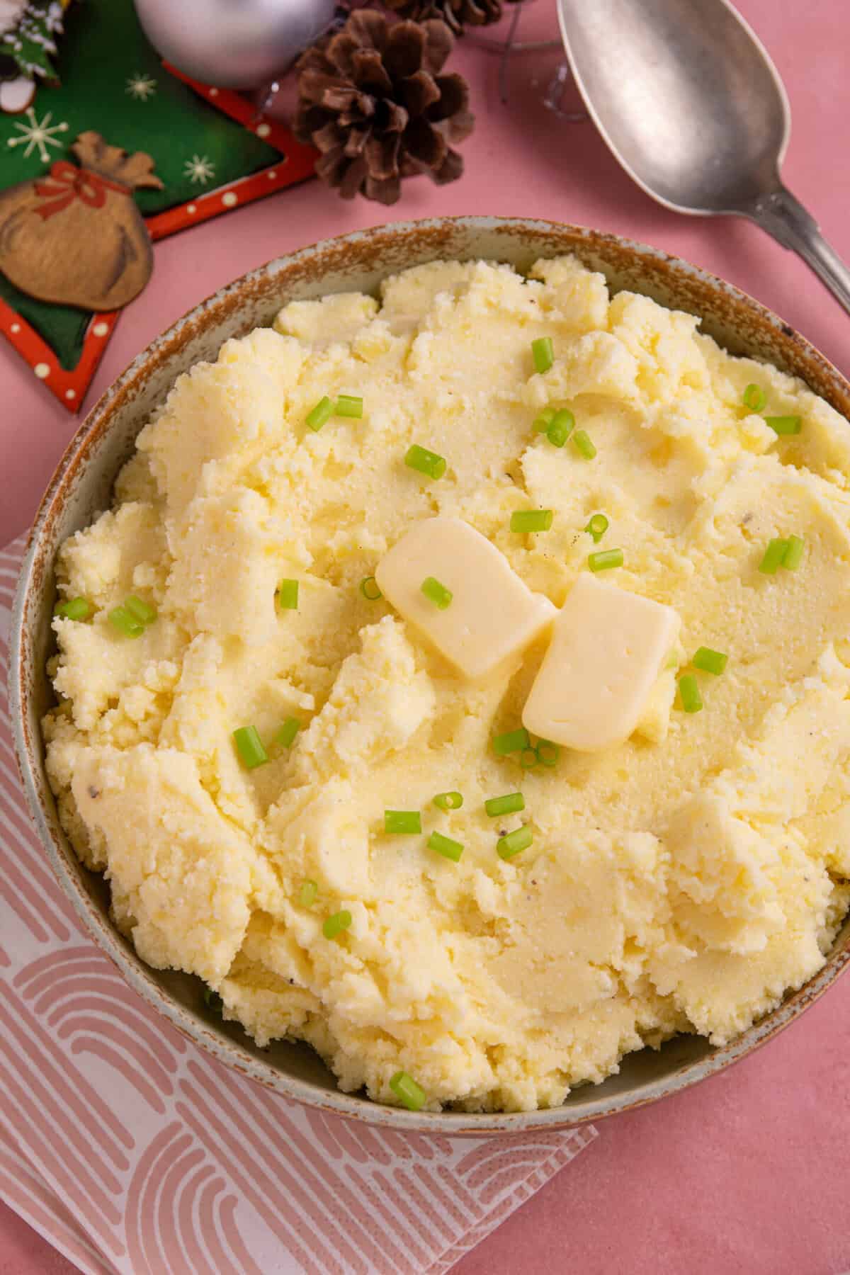 A bowl of cottage cheese mashed potato with christmas decorations next to it.