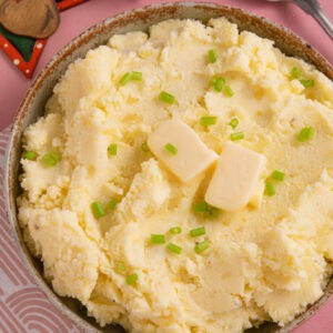 A bowl of cottage cheese mashed potato with christmas decorations next to it.