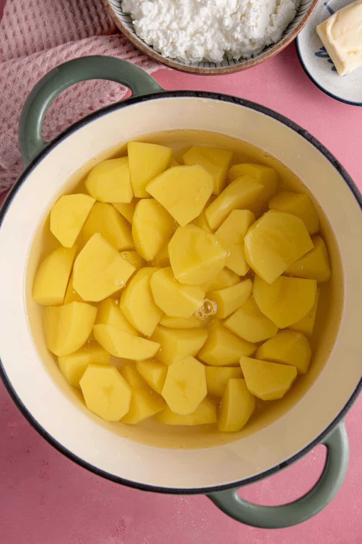 Peel and quarter the potatoes then add them to a pan of water and boil.