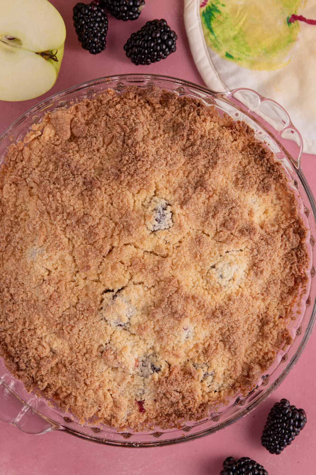 Bake the apple and blackberry crumble until golden and serve hot.