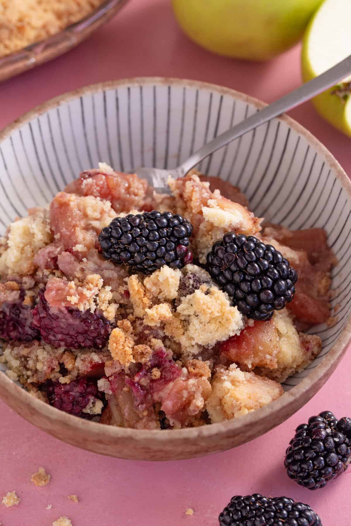 A bowl of blackberry and apple crumble.