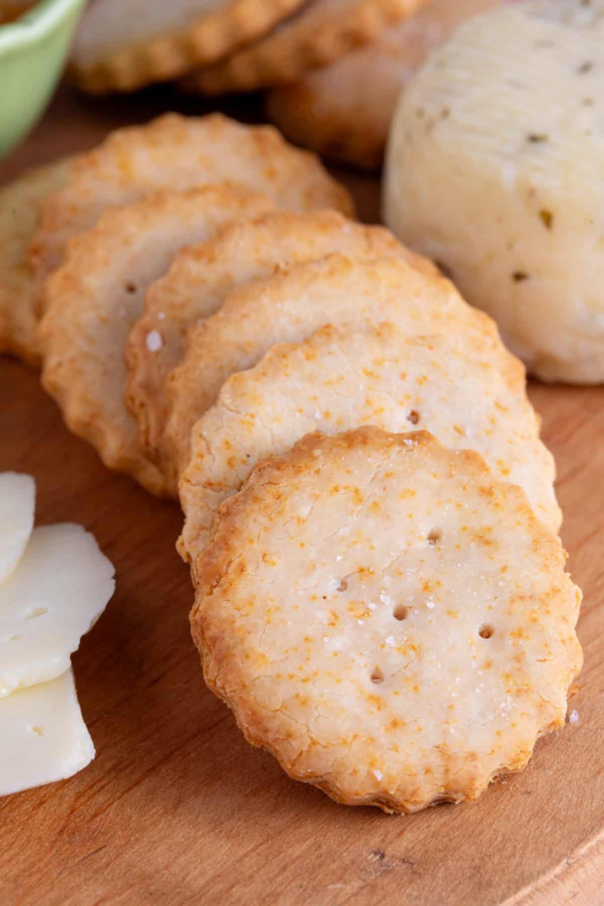 Gluten free Ritz Crackers on a wooden serving board.