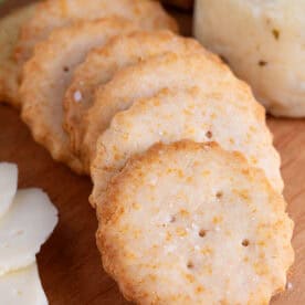 Gluten free Ritz Crackers on a wooden serving board.