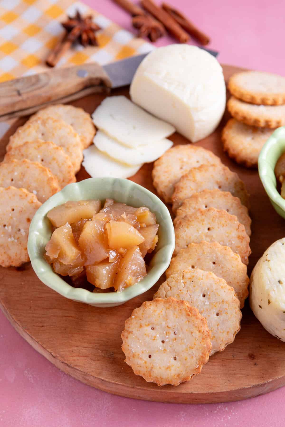 Gluten free Ritz Crackers on a wooden serving board with cheese and chutney.
