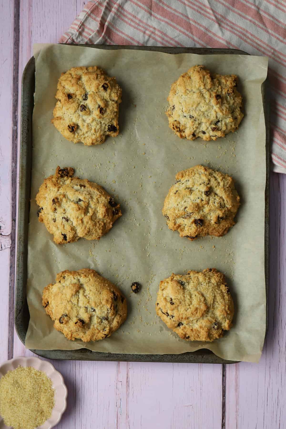 A baking tray with 6 gluten free rock cakes on.