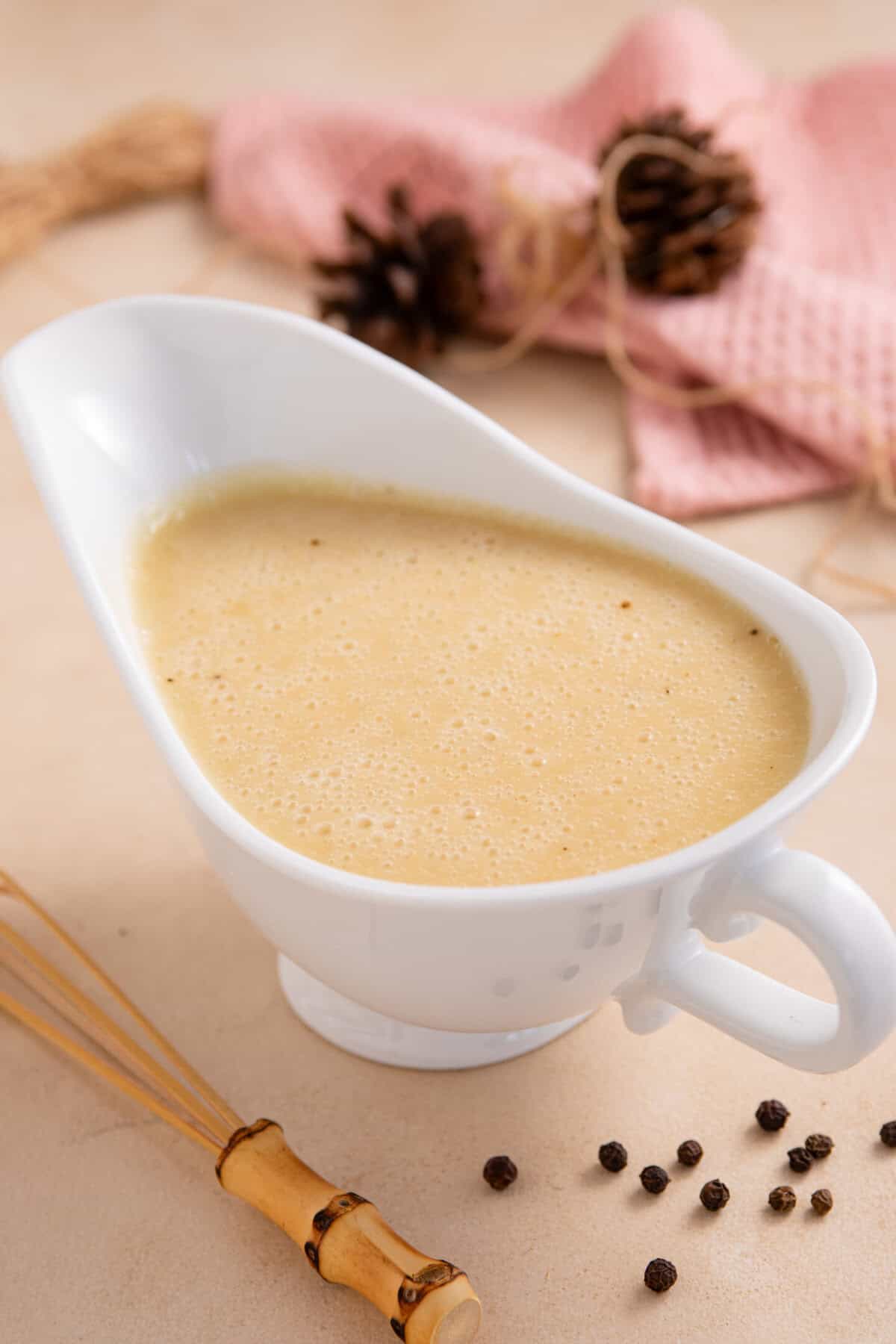 A jug of miso gravy with festive decor behind.