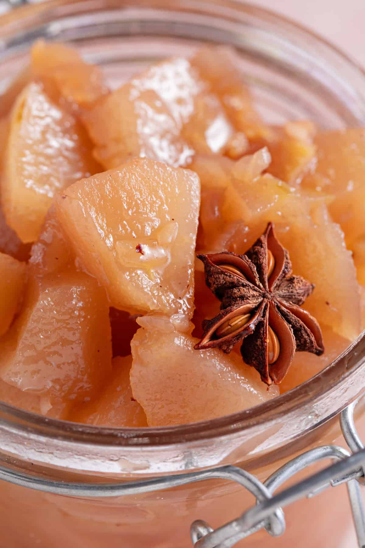 Close up of pear chutney with a whole star anise on top.