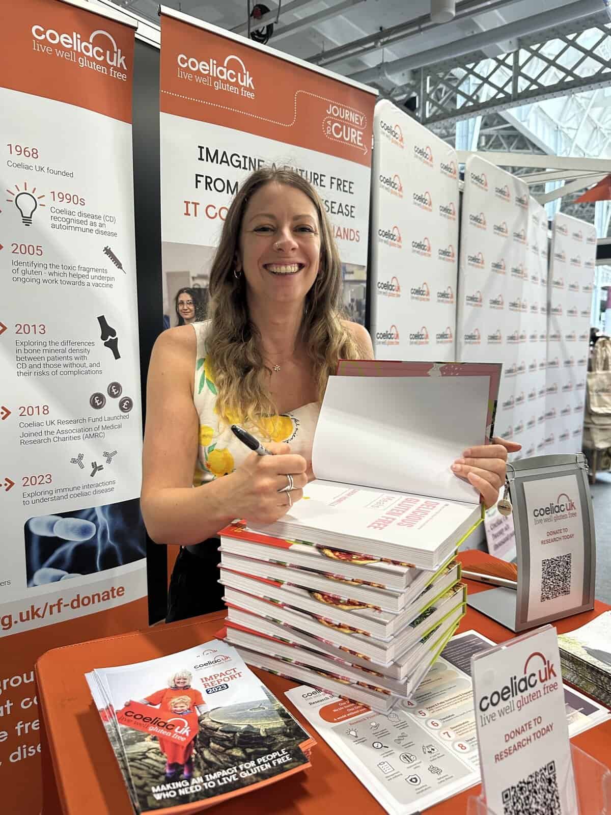 Author Sarah Howells signing copies of her book on a Coeliac UK stand.