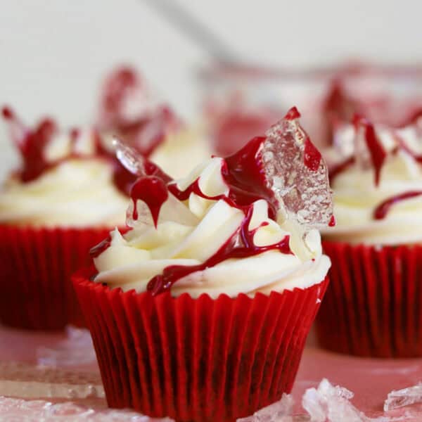Gluten free cupcakes with cream cheese frosting, edible broken glass and edible blood on top.