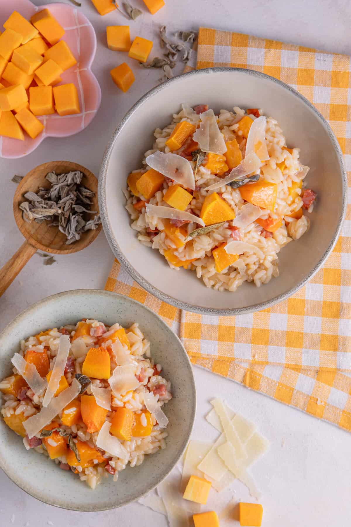 Two bowls of butternut squash and chorizo risotto with sage and parmesan.