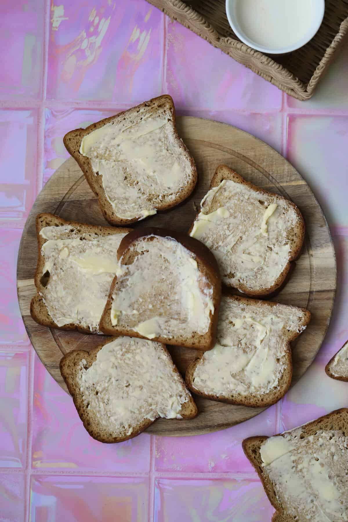 Slices of gluten free bread with butter spread on them thickly.