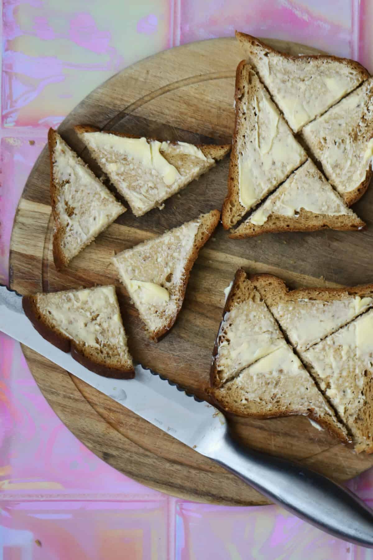 Cut the buttered gluten free bread slices into quarters in a triangle shape.
