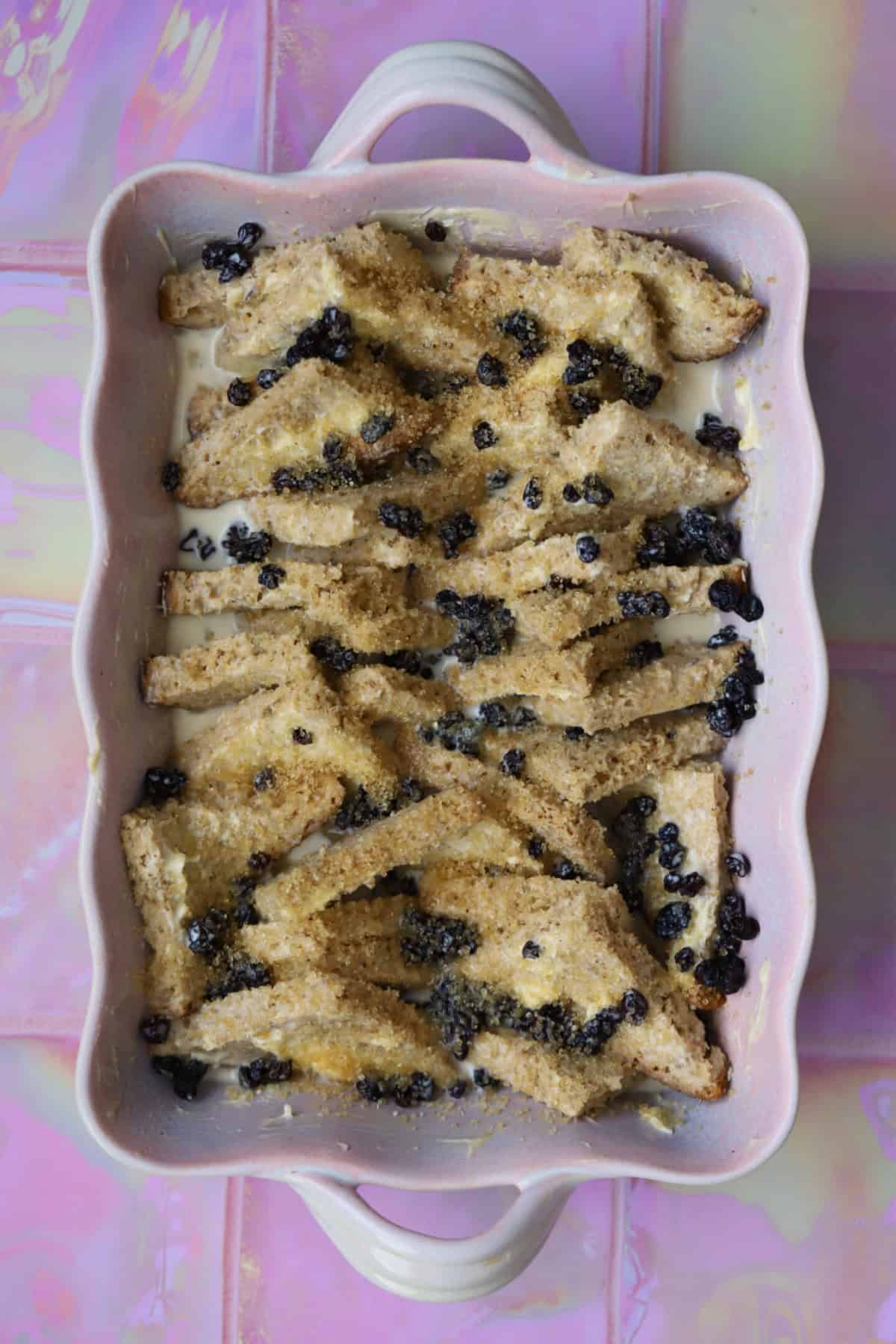 Scatter in the currants, pour over the custard then sprinkle with sugar.