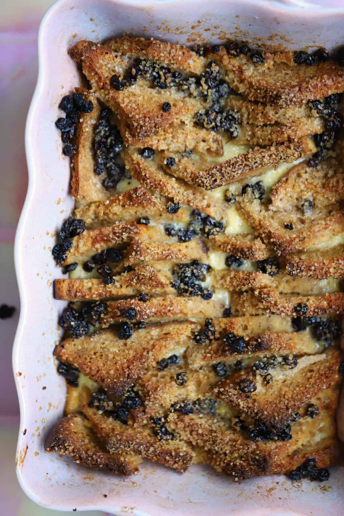 Gluten free bread and butter pudding in a pink dish.