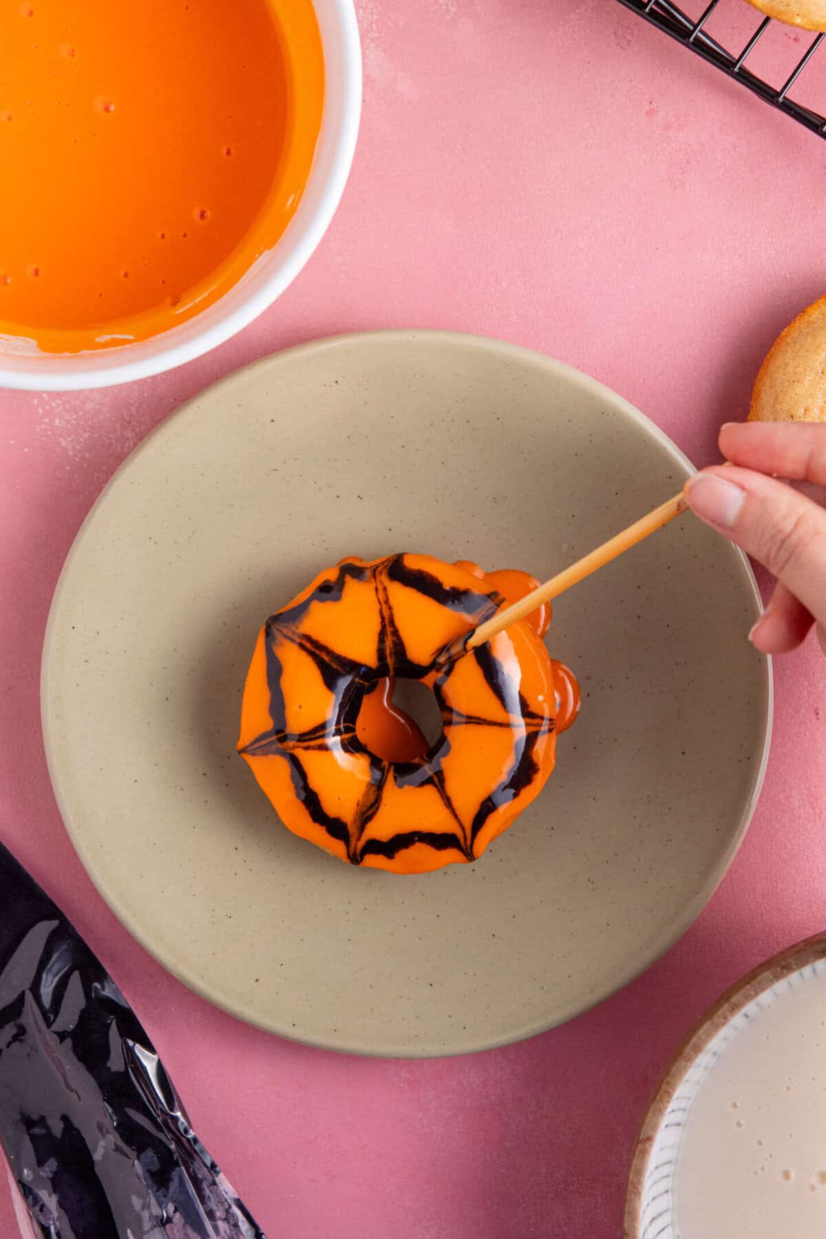 Pipe circles of icing onto the doughnuts then use a cocktail stick to make the spiderwebs.