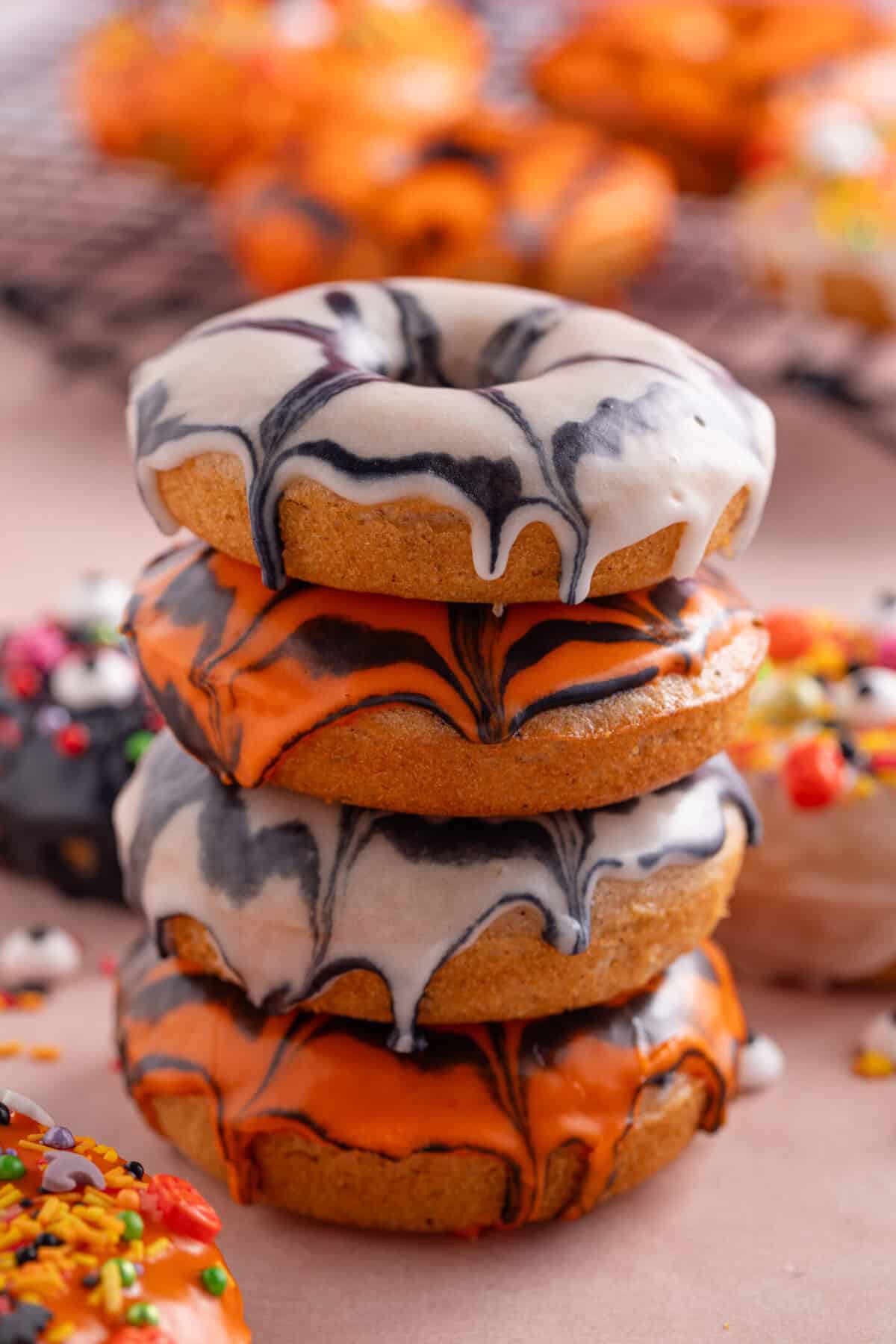 A stack of gluten free spiderweb icing donuts.