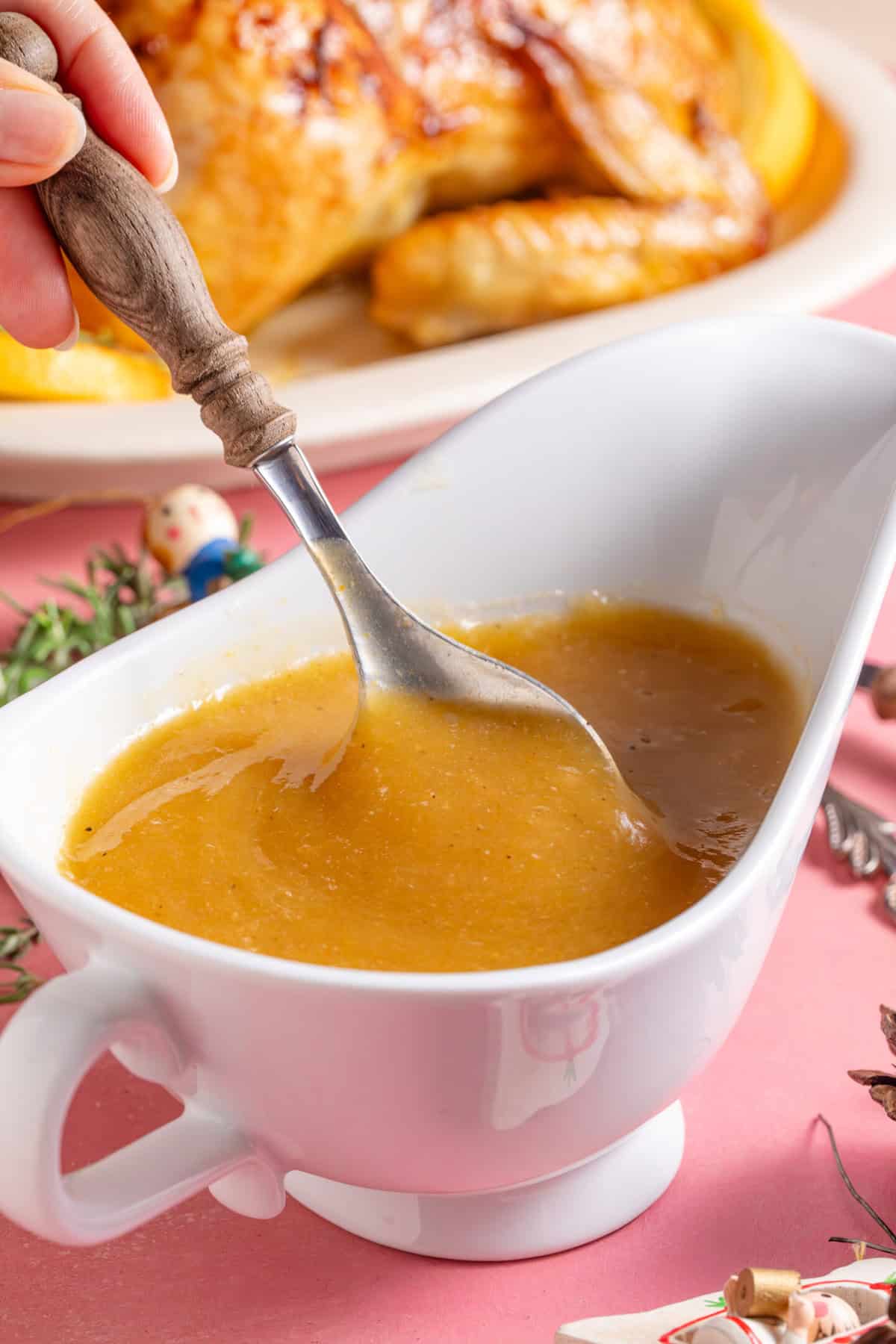 A jug of gluten free gravy with a spoon.