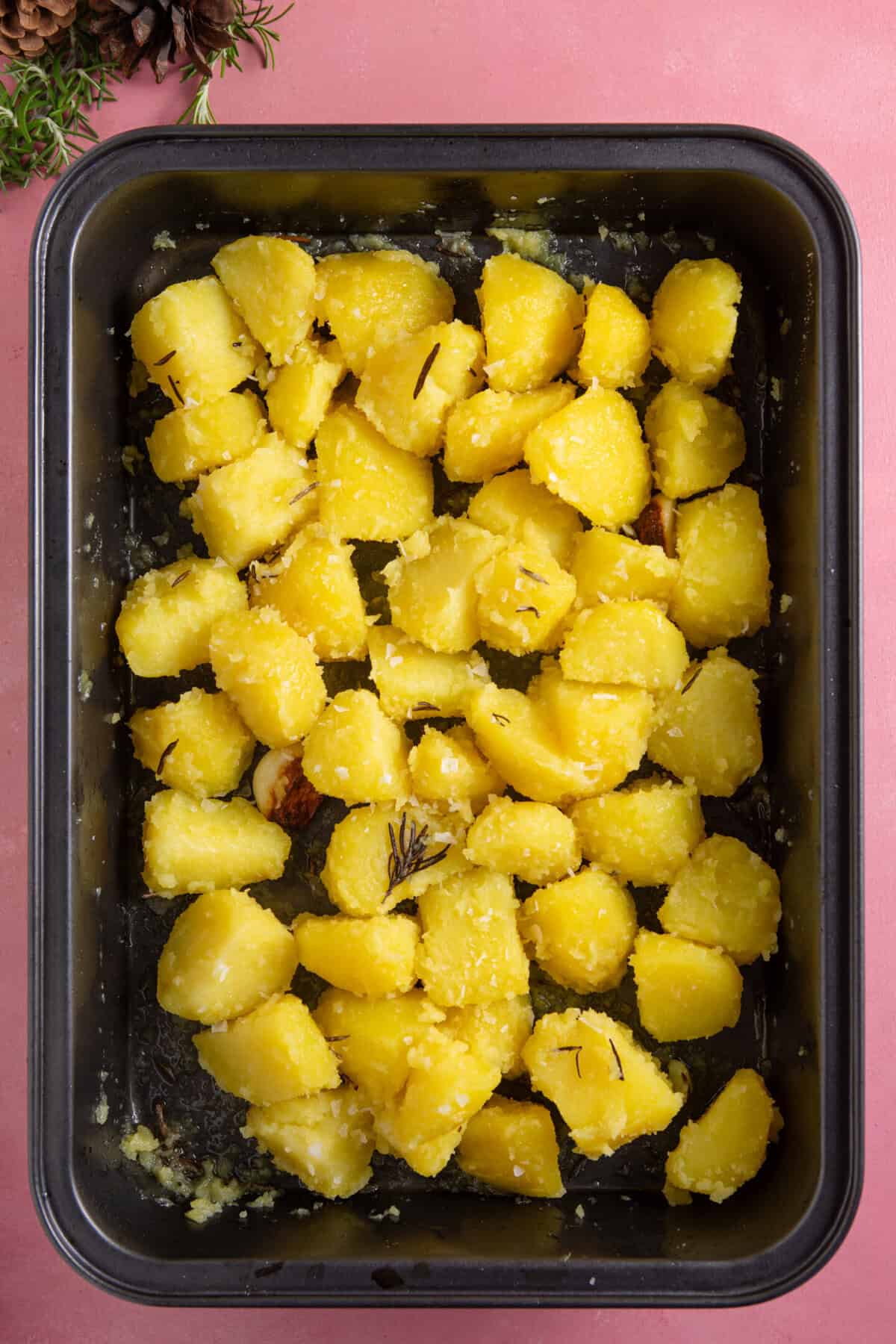 Add the drained potatoes to the hot oil, toss and roast until crispy.