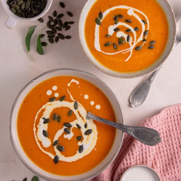 Two bowls of gluten free roasted pumpkin soup.