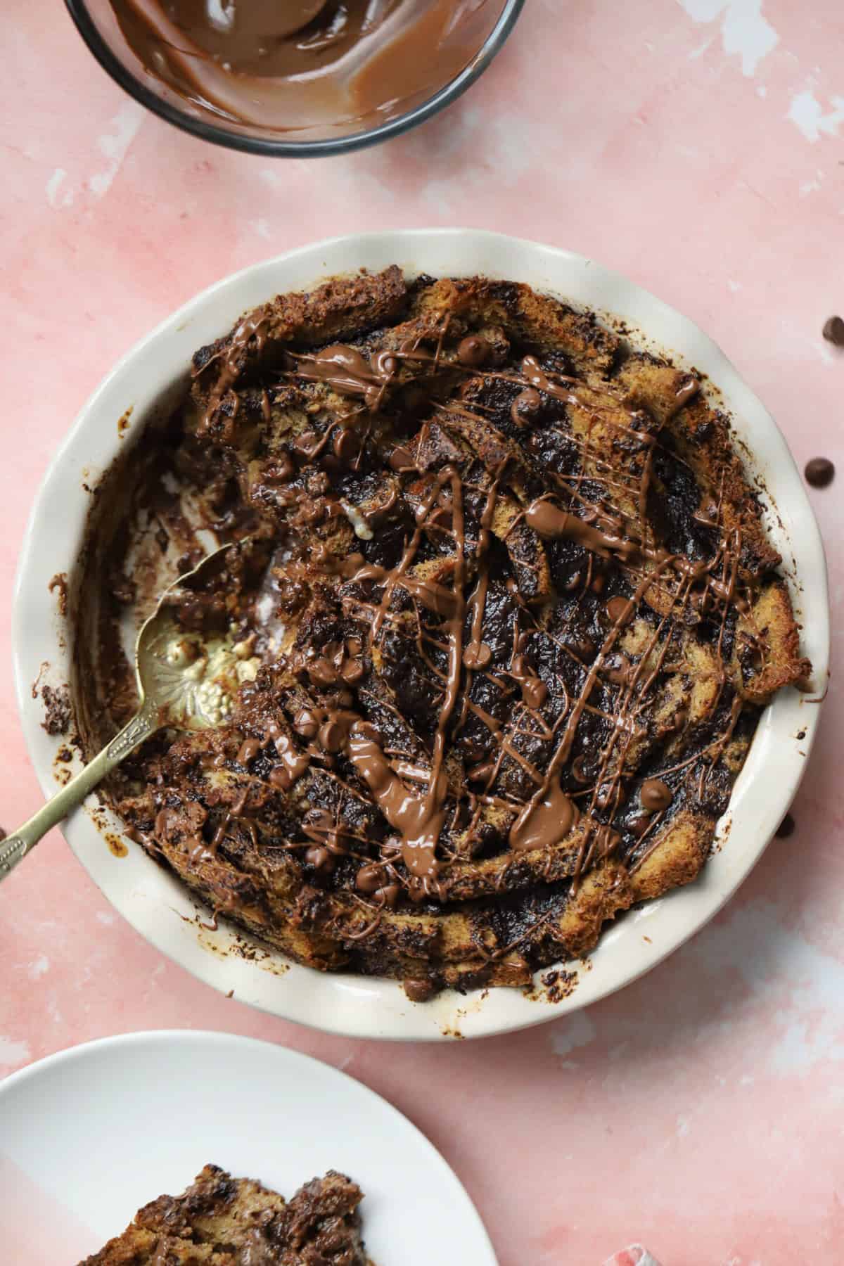 A chocolate bread and butter pudding with a spoon.