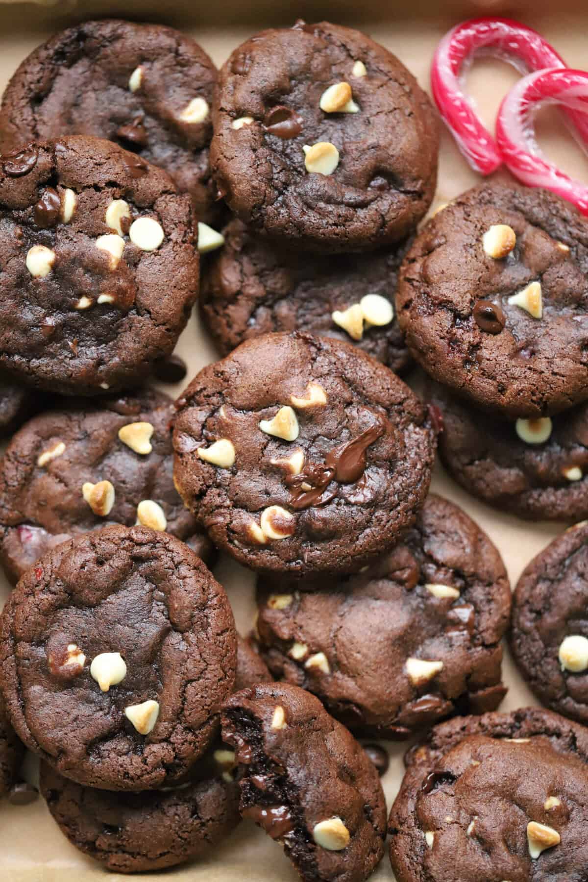 A pile of gluten free peppermint bark cookies - gooey chocolate mint cookies with chunks of white and dark chocolate.