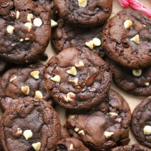 A pile of gluten free peppermint bark cookies - gooey chocolate mint cookies with chunks of white and dark chocolate.