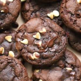 A pile of gluten free peppermint bark cookies - gooey chocolate mint cookies with chunks of white and dark chocolate.