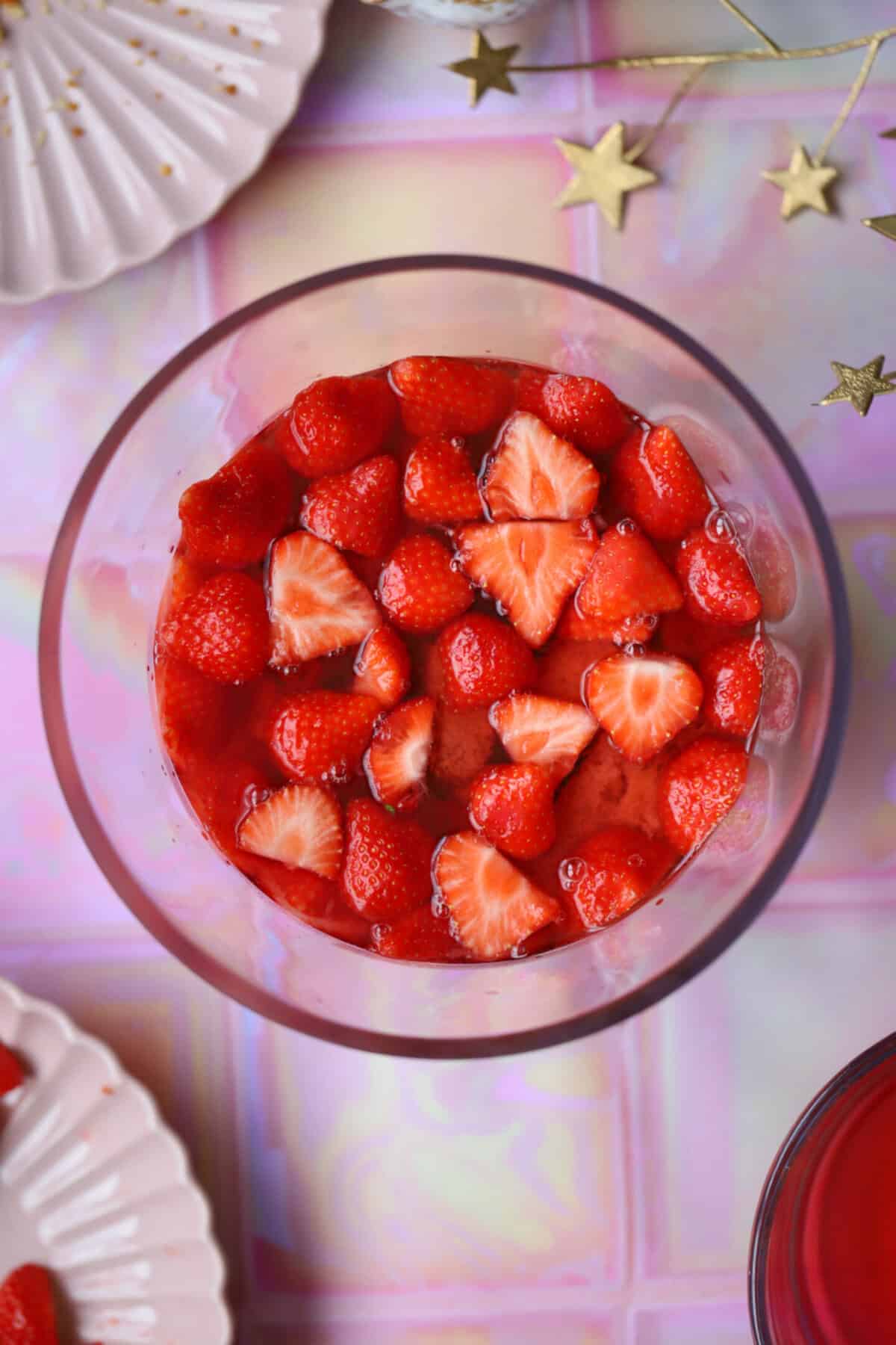 Process shot of a gluten free trifle recipe showing the jelly poured to the bottom of the fruit layer.