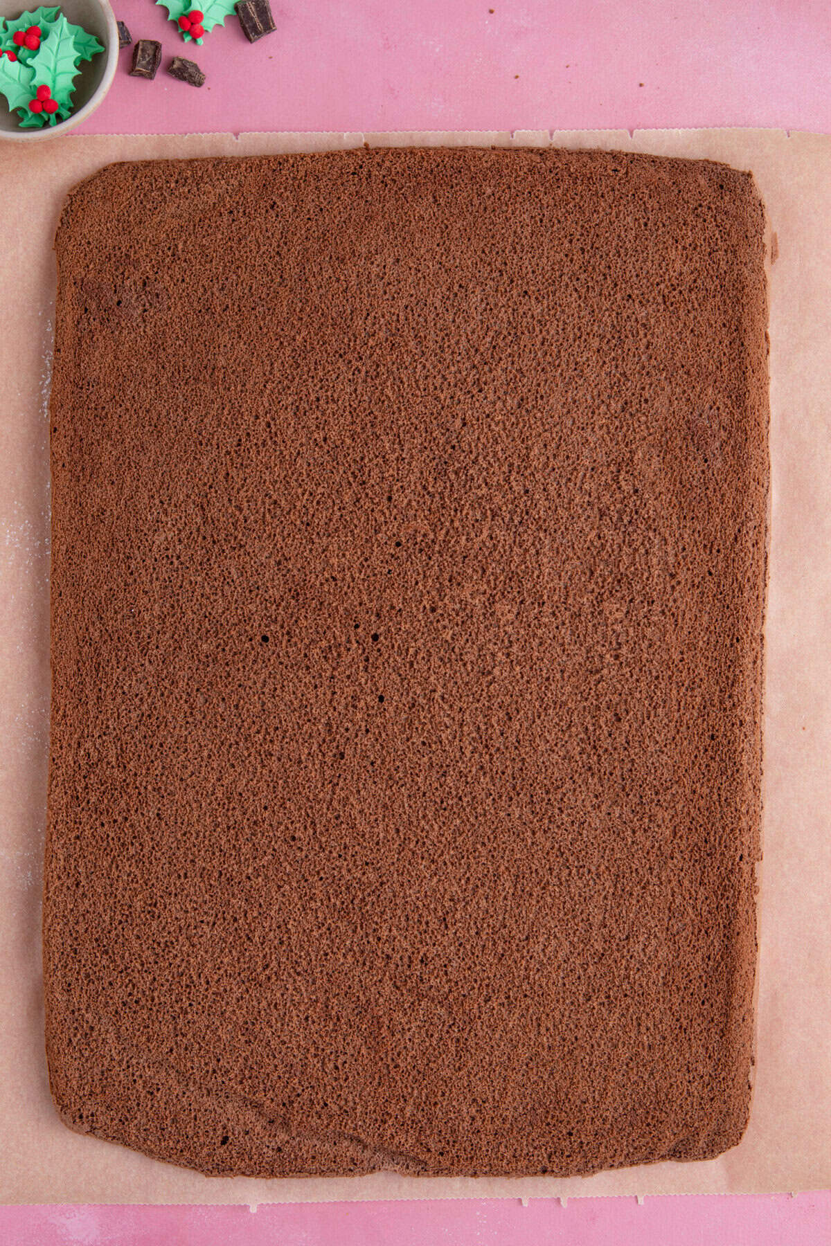 Bake the chocolate yule log sponge until it just starts to shrink from the edge of the pan.