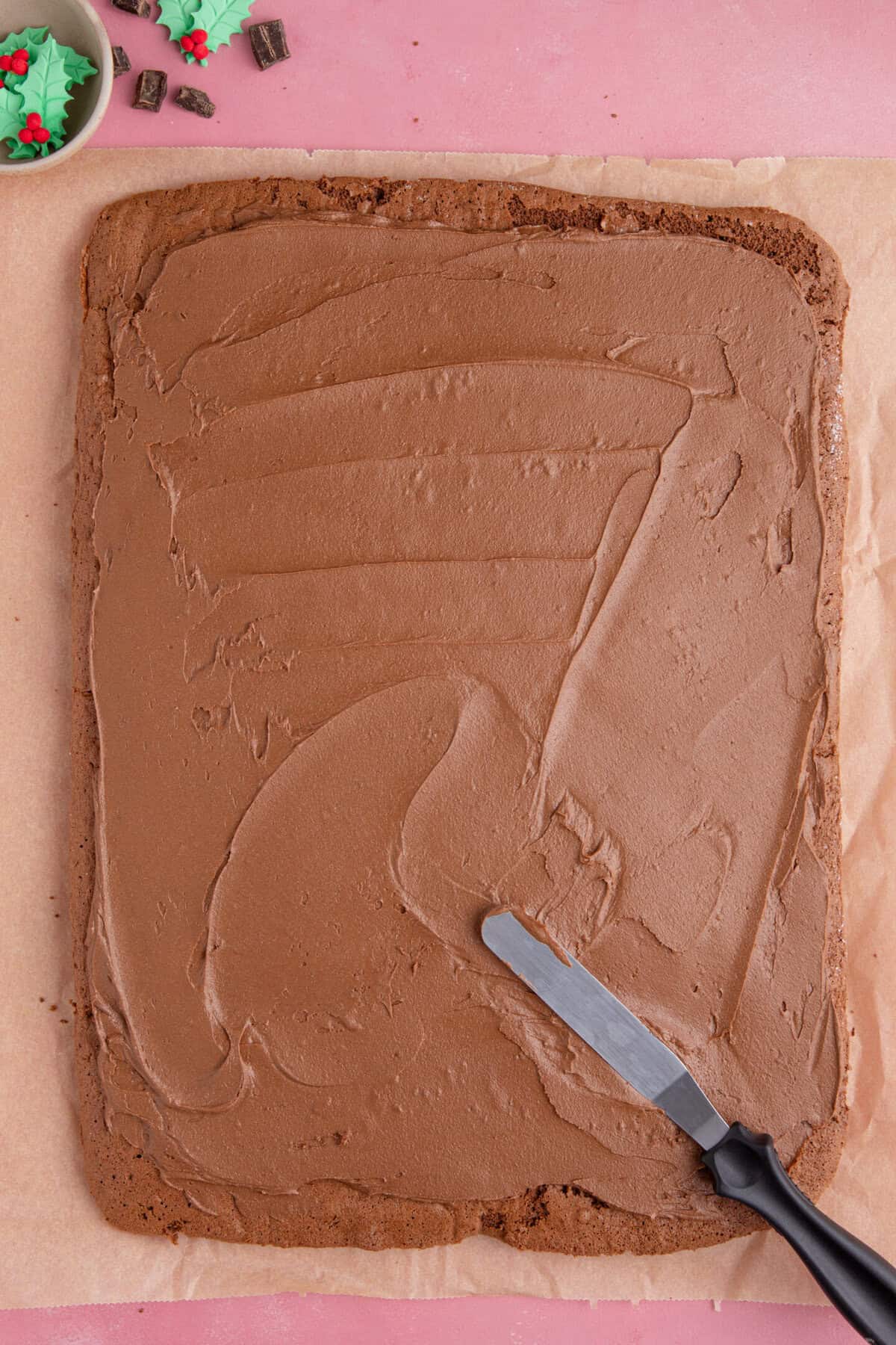 Unroll the cooled sponge and spread with the buttercream before rolling back up.