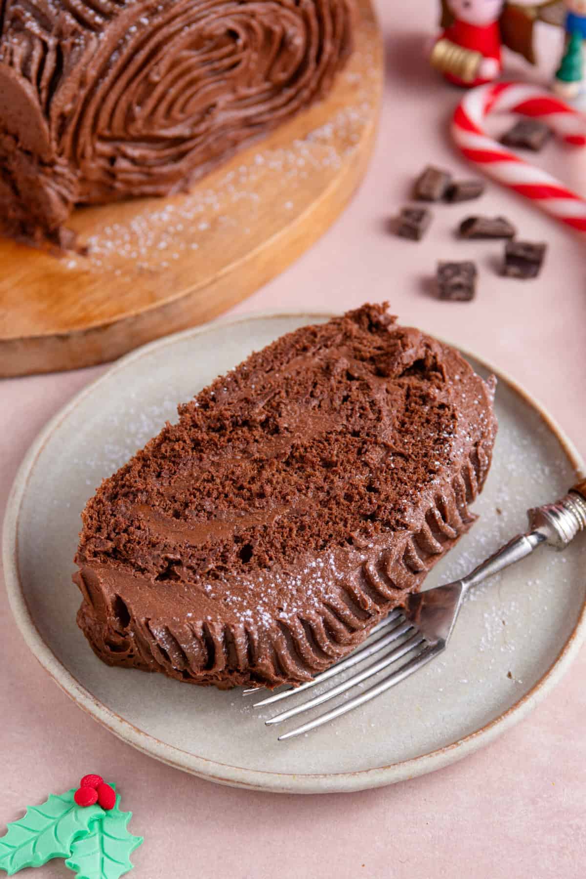 A slice of gluten free yule log showing a swirl of frosting inside.