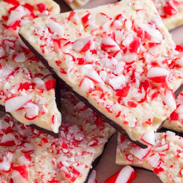 A stack of slabs of peppermint bark with crushed candy canes on top.