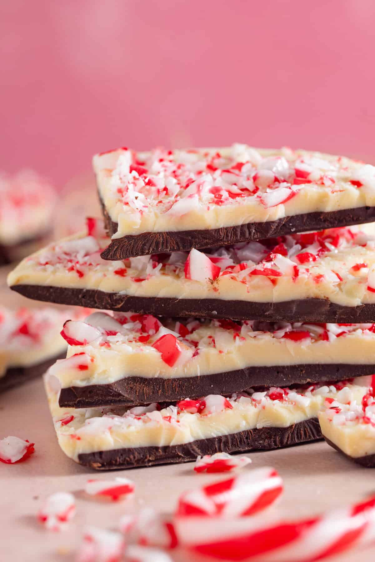 A stack of peppermint bark, which has layers of dark and white chocolate with crushed candy canes on top.