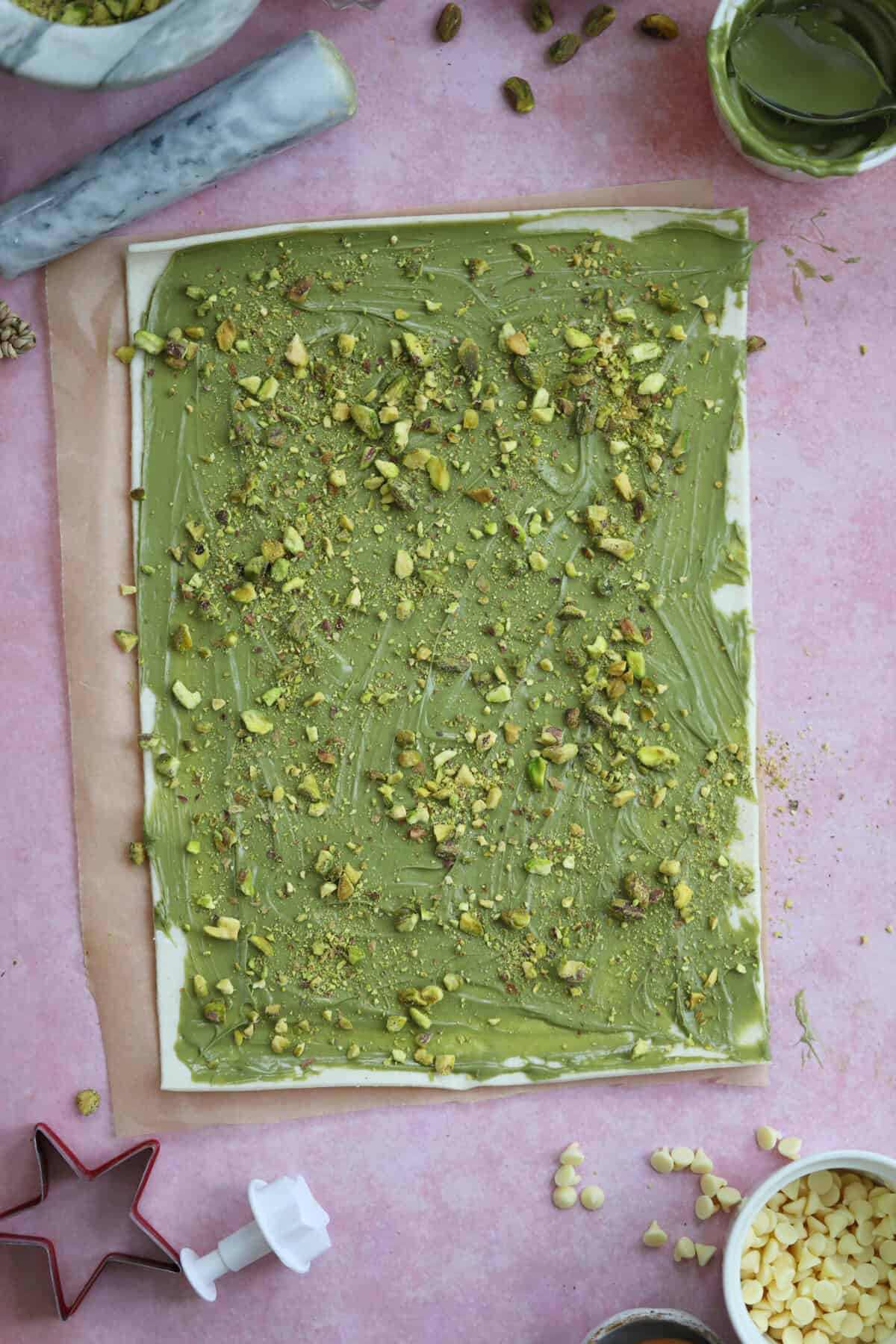 Roll out the puff pastry and then spread with pistachio paste and crushed pistachios.