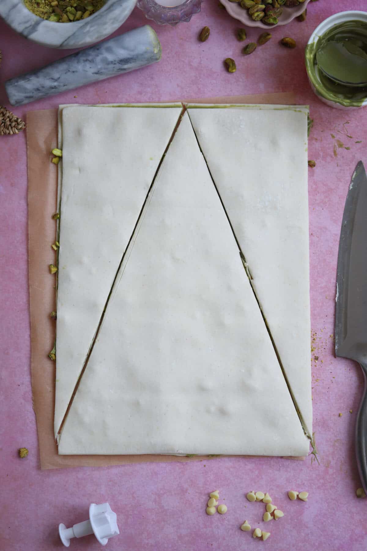 Lay the second puff pastry sheet on top and then cut a triangle shape.