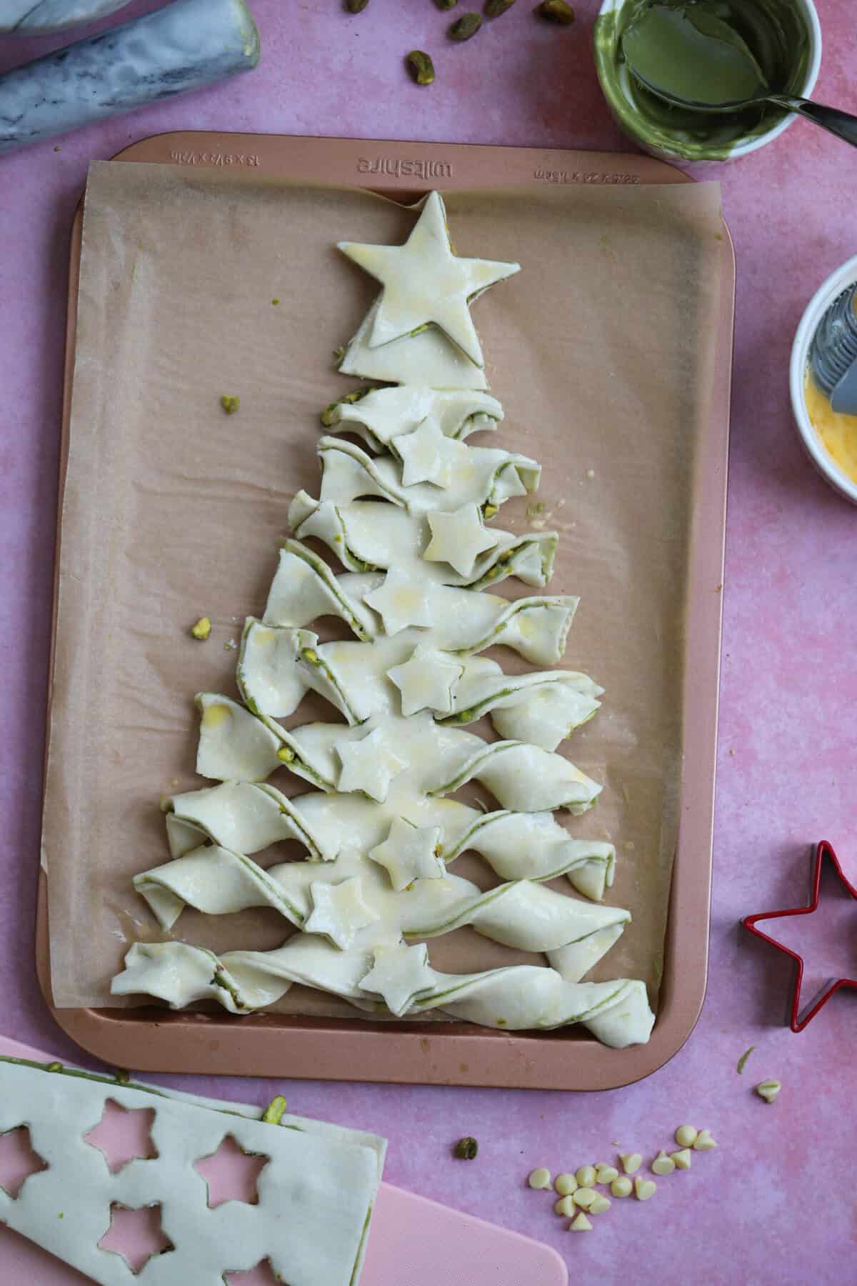 Decorate the tree with the stars, brush with beaten egg and then bake.