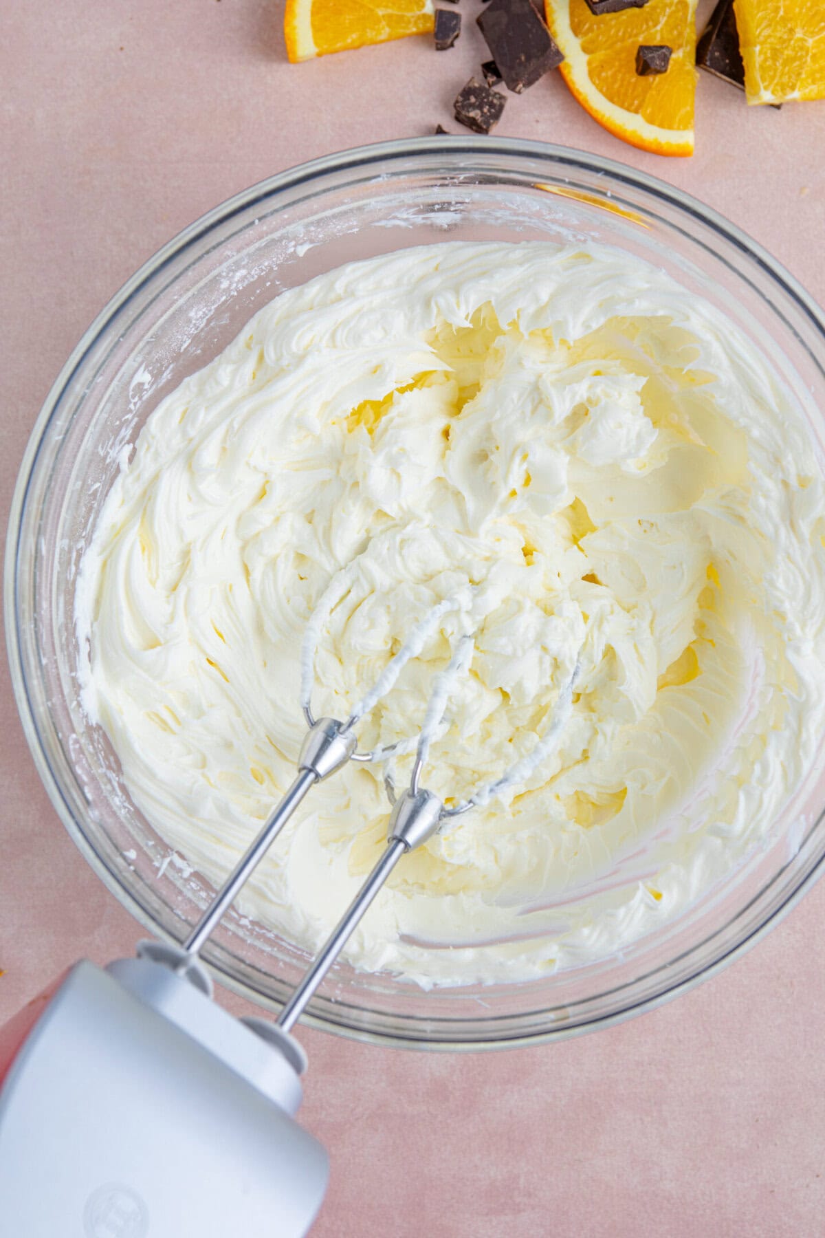 Process shot of a chocolate orange cheesecake recipe showing the start of the topping in a bowl.