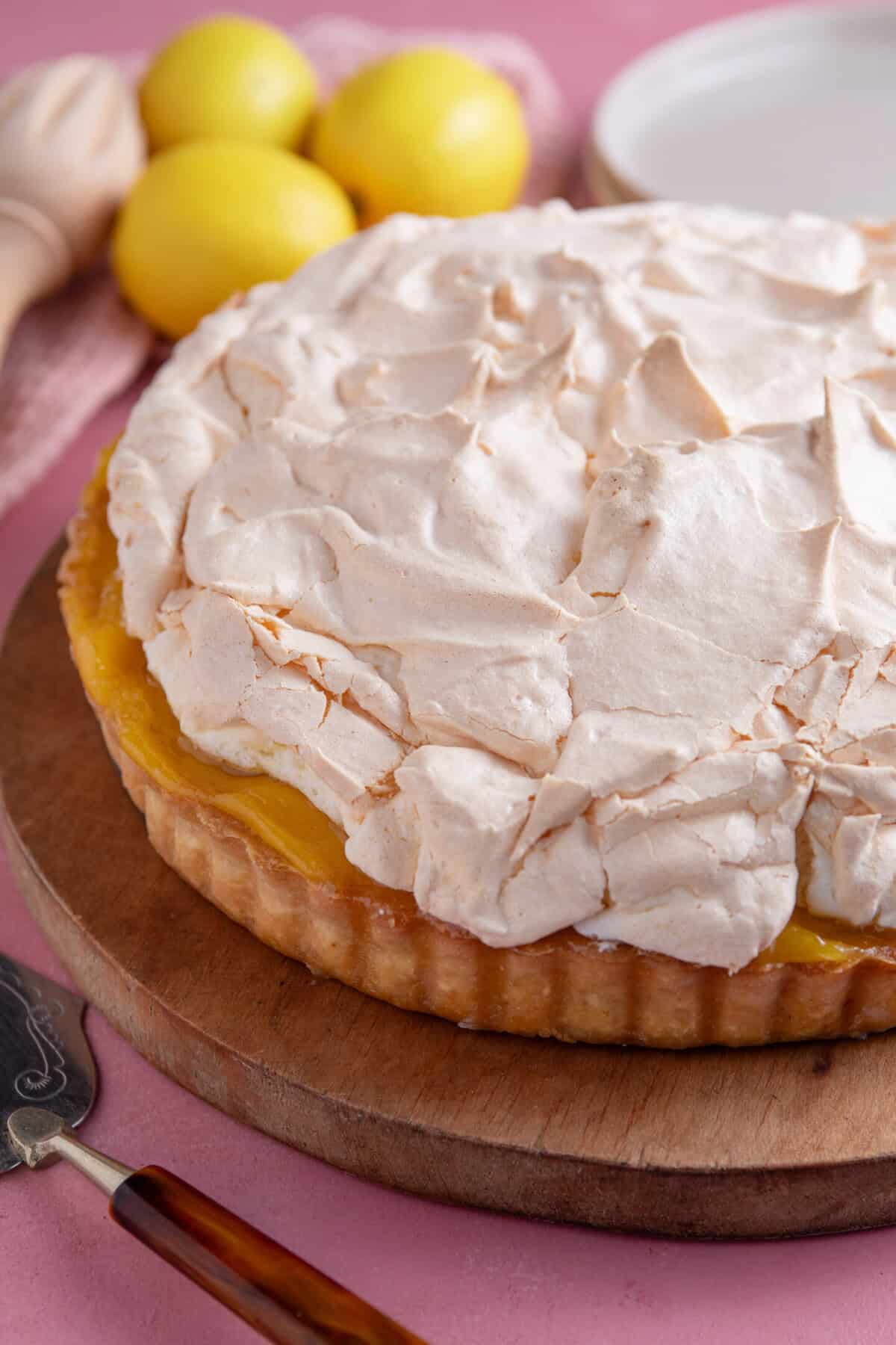 A gluten free lemon meringue pie on a wooden board.