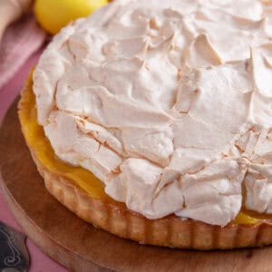 A gluten free lemon meringue pie on a wooden board.