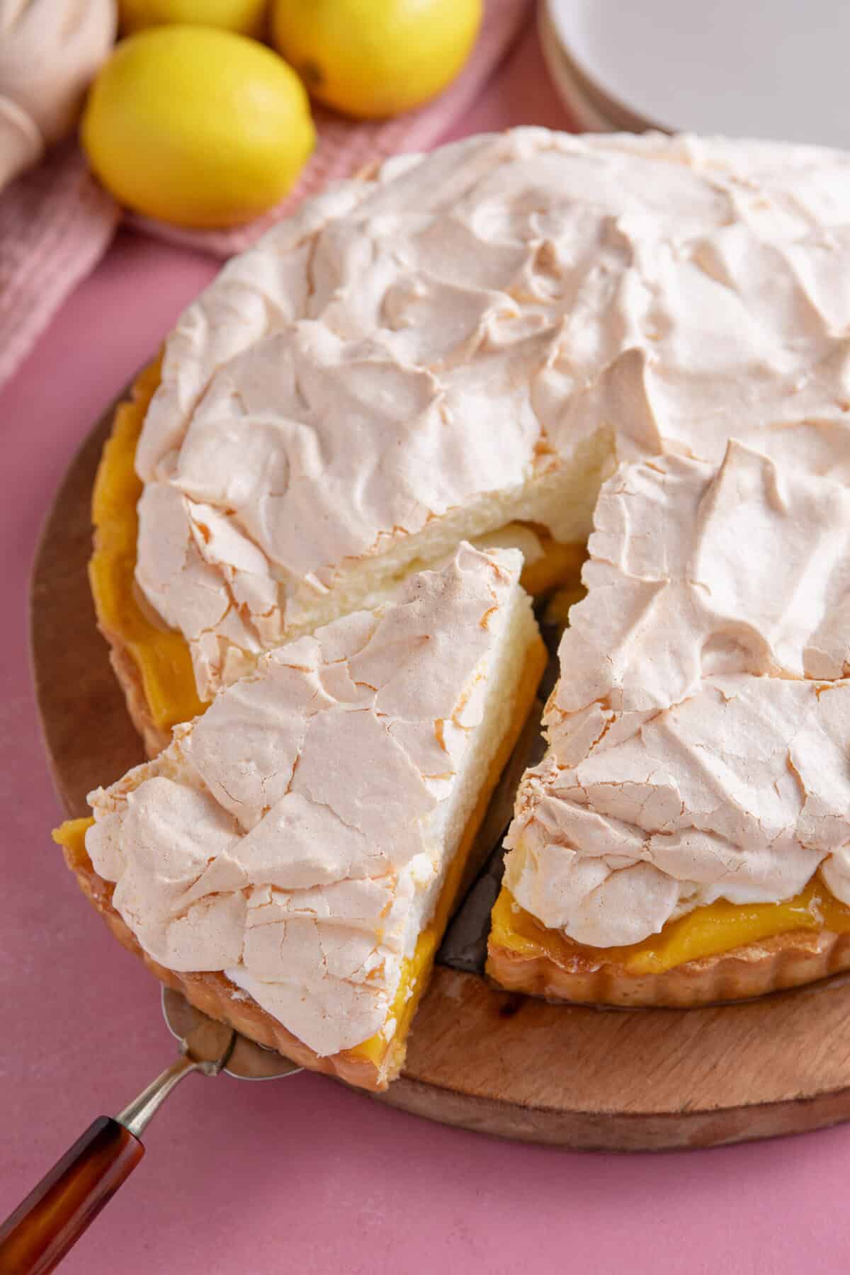 A gluten free lemon meringue pie with a slice taken out.
