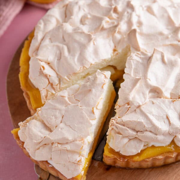 A gluten free lemon meringue pie with a slice taken out.