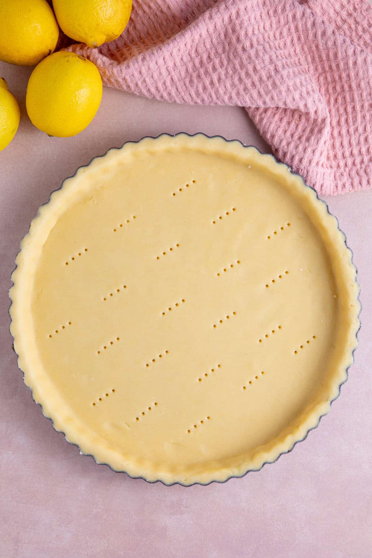 Process shot of a gluten free lemon meringue pie recipe showing the uncooked pastry base in the tin.