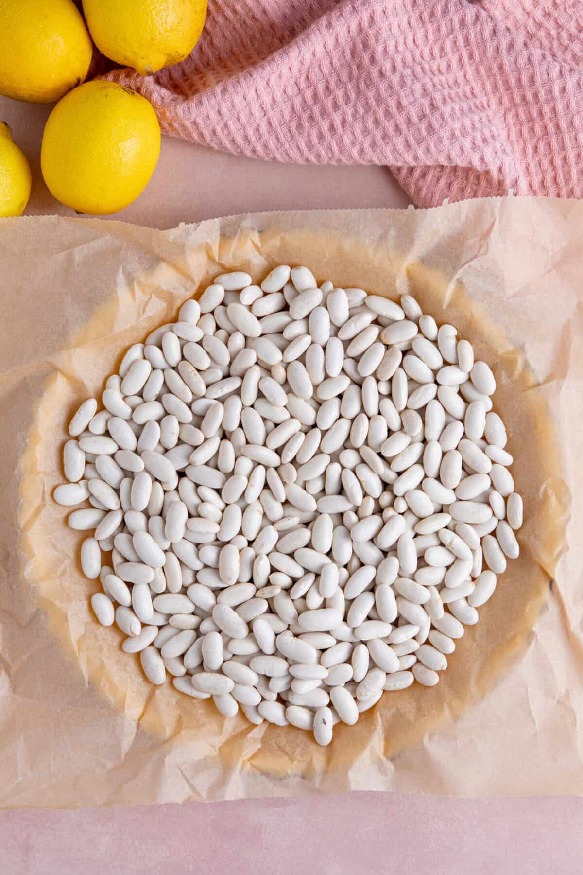 Process shot of a gluten free lemon meringue pie recipe showing the pastry ready for blind baking with baking beans.
