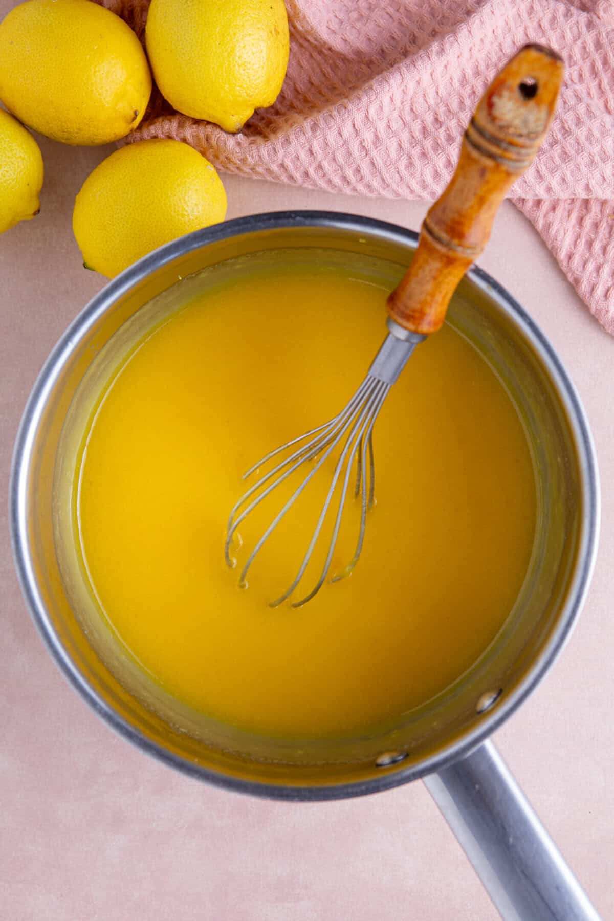 Process shot of a gluten free lemon meringue pie recipe showing the lemon curd in a pan.