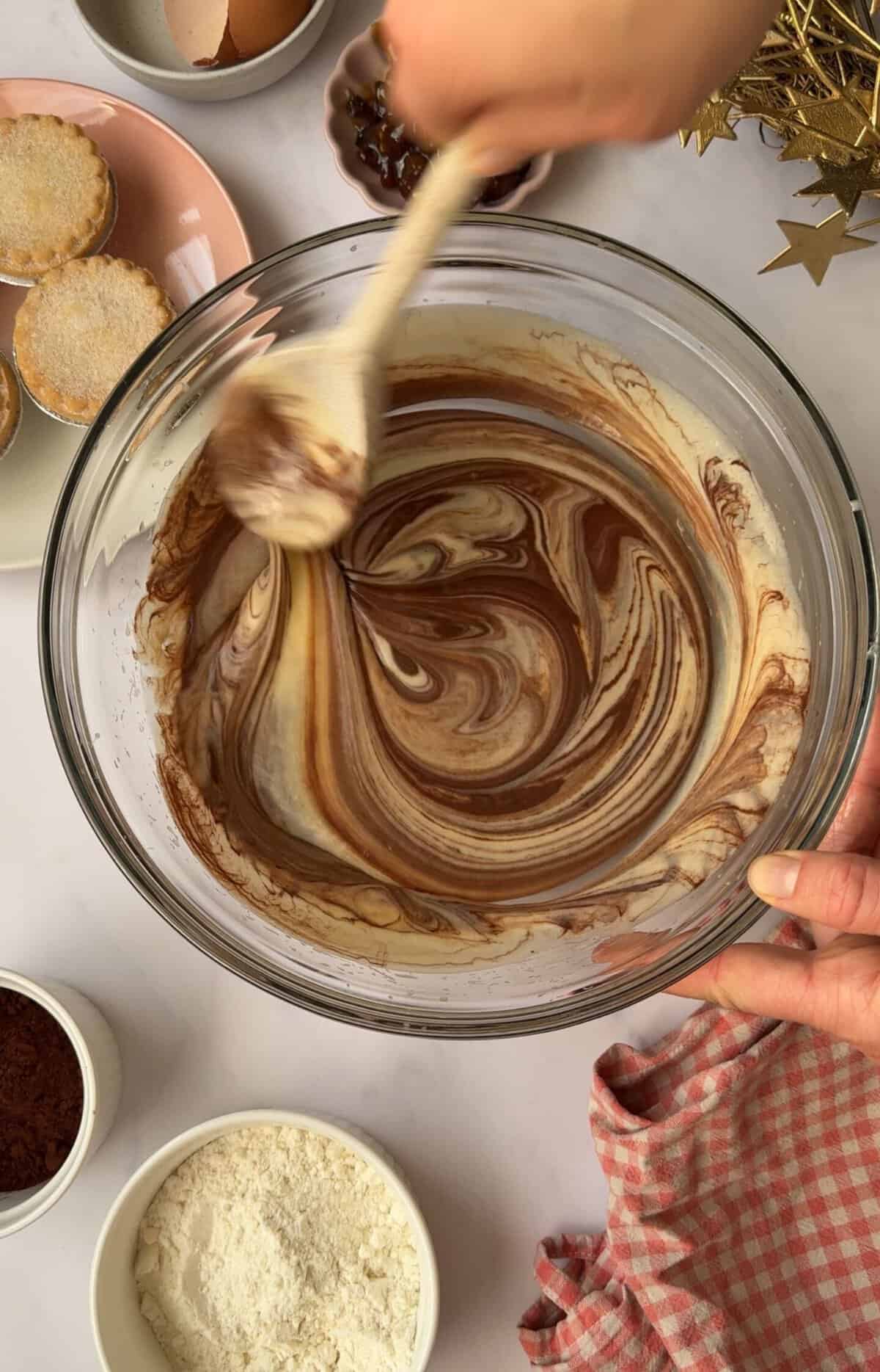 Process shot of mince pie brownies recipe showing the melted chocolate swirled into the batter.