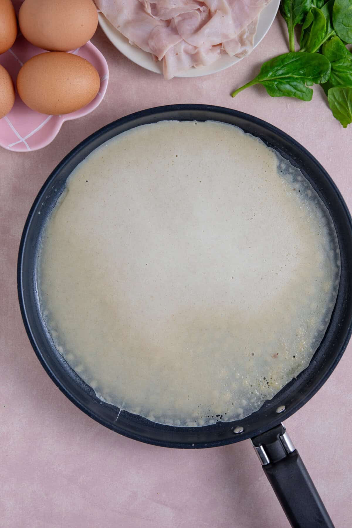 Process shot of buckwheat pancakes recipe showing the pancake cooking in a pan.
