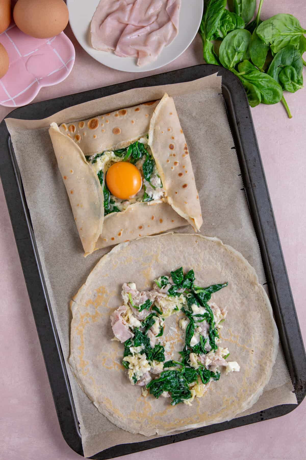 Process shot of buckwheat pancakes recipe showing the pancake with filling in the centre, and one being constructed.
