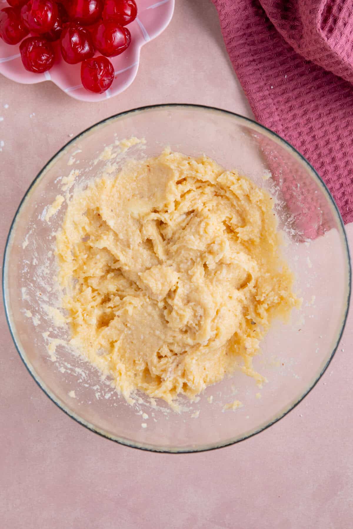 Process shot of gluten free cherry bakewells recipe showing the gluten free frangipane mixture in a bowl.